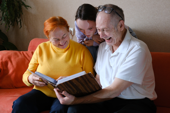grandparents grandfather Grandmother and young granddaughter spent great time together, family members look at photos from the youth of an elderly parent, through the pages of the album.